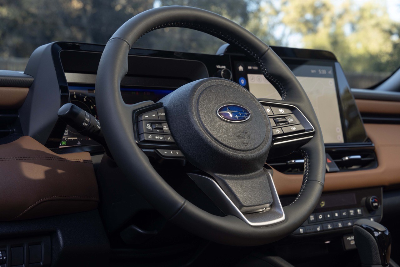 Close-up of the Subaru Outback steering wheel and its thumb controls, with the driver's display behind